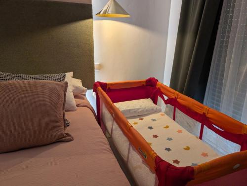 a baby crib sitting next to a bed in a room at La Palomilla in Avila