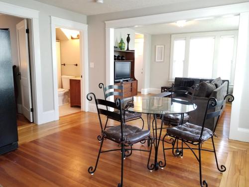 a dining room and living room with a table and chairs at Bright Front Facing Unit - Private Front Farmers Porch in Manchester
