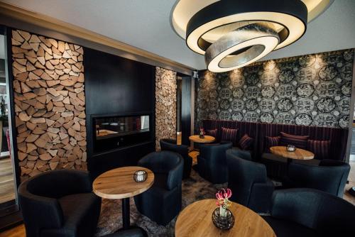 a restaurant with tables and chairs and a chandelier at Hotel Schmachtendorf in Oberhausen