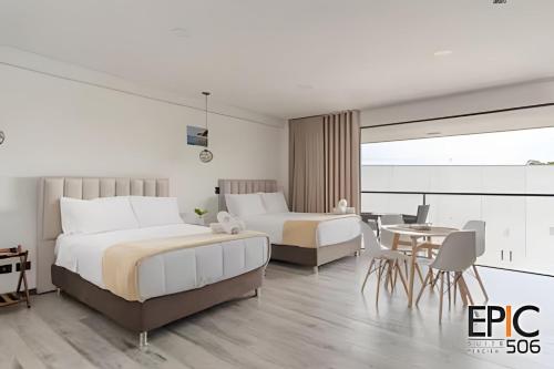 a hotel room with two beds and a table at Epic Suite 506 Deluxe Aeropuerto in Cuba