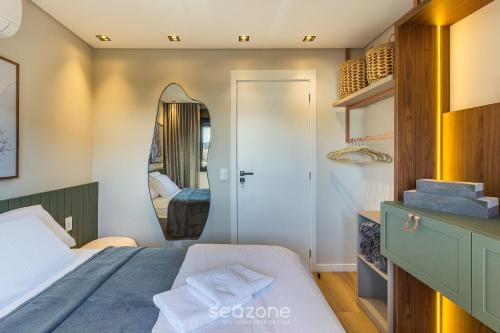 a small bedroom with a bed and a mirror at DLH - Apartamentos no Coração de Gramado Próximos à Rua Coberta in Gramado