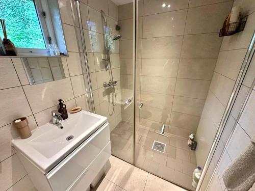 a white bathroom with a shower and a sink at Luxury & Central Arendal Home in Arendal