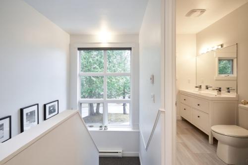 une salle de bain blanche avec un lavabo et des toilettes dans l'établissement La Jumelle d'en bas - 5 chambres - 15 personnes, à Saint-Ferréol-les-Neiges