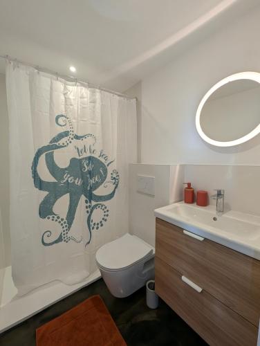 a bathroom with a shower curtain with an octopus on it at Esprit Cabane au Cœur du Teich in Le Teich