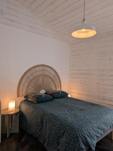 a bedroom with a large bed in a room at Esprit Cabane au Cœur du Teich in Le Teich