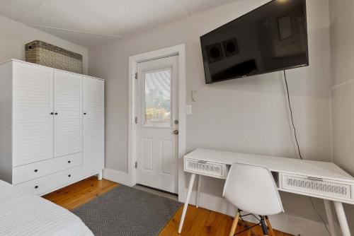 Un dormitorio con un escritorio y un televisor en la pared. en Sleek & Bright 1st Flr Studio Short -Midterm Stays, en Manchester