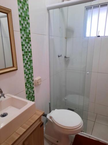 a bathroom with a shower and a toilet and a sink at Estúdio acolhedor e versátil in Laguna