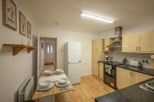 une cuisine avec un réfrigérateur blanc et des placards en bois dans l'établissement Rochdale Residence, à Royal Tunbridge Wells