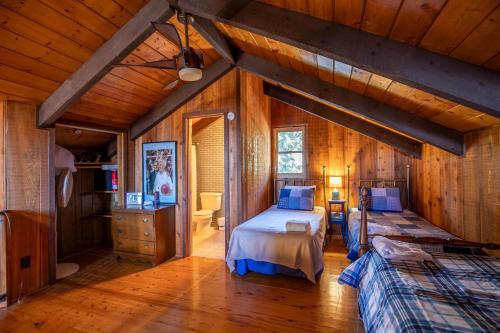 a bedroom with two beds in a room with wooden walls at On Any Sunday in Blowing Rock