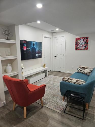 a living room with a couch and a chair at Beautiful, serene and modern! in Saskatoon