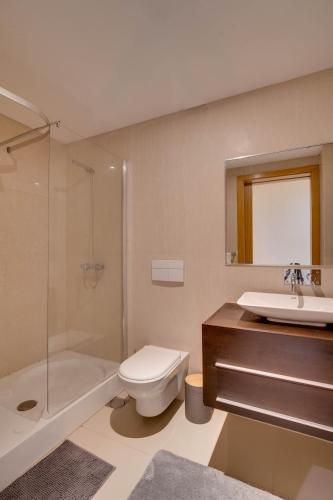 a bathroom with a toilet and a sink and a shower at Sunscape T2 in Funchal