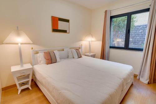a bedroom with a large white bed and a window at Sunscape T2 in Funchal