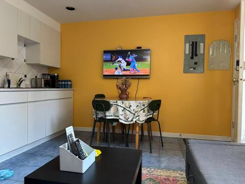 a living room with a television on a wall at UBC Two-Bedroom Suite - Steps from Beach, Park & Golf - Full Kitchen in Vancouver