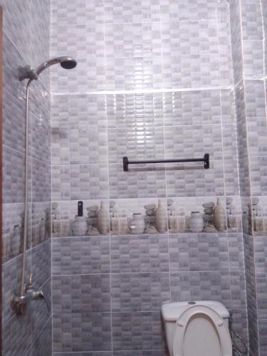 a bathroom with a toilet and a glass shower at Appartement fun in Dakar