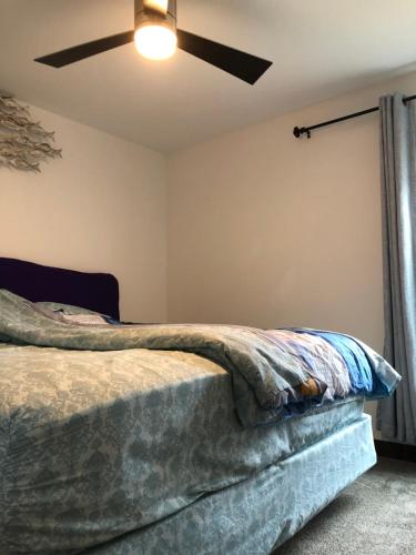 Un dormitorio con una cama con ventilador de techo. en Newly built single family home, en Cedar Rapids
