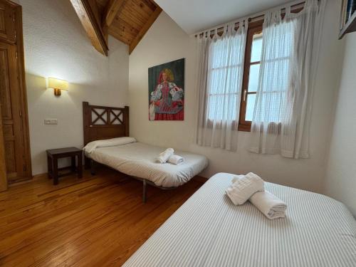 een kamer met twee bedden en een raam bij B15 - Ático Los Copos - Villmor in Benasque