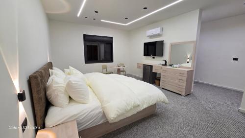 een slaapkamer met een bed, een bureau en een spiegel bij Jeeso hotel in Jerash