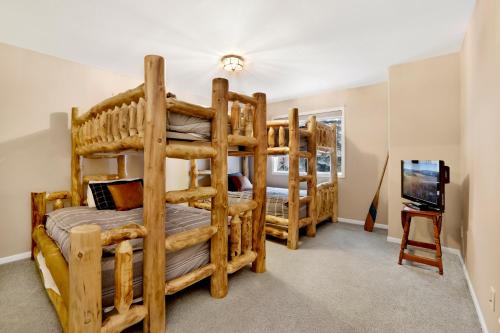 a bedroom with two bunk beds and a television at Castle Glen Gem #2220 in Big Bear Lake