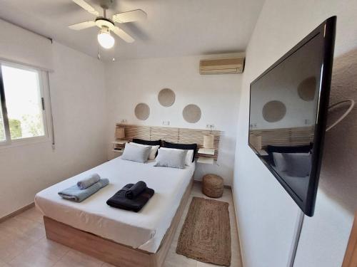 a bedroom with a bed and a flat screen tv at Harea Coastal Penthouse Naturist Area in Playas de Vera