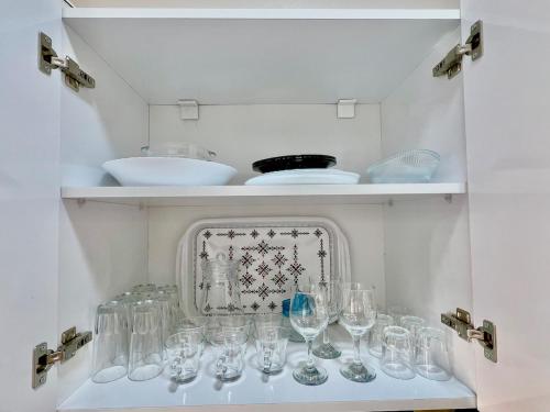 un estante lleno de copas de vino en una pared en A8 Getaway in Tamraght, Fiber Wi-Fi, 5 min to beach, en Tamraght Ouzdar