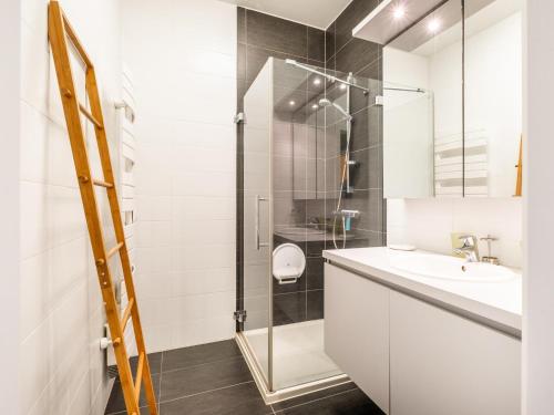 a white bathroom with a sink and a shower at LeVillage in Sint-Idesbald