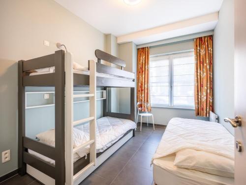 a bedroom with two bunk beds and a window at LeVillage in Sint-Idesbald