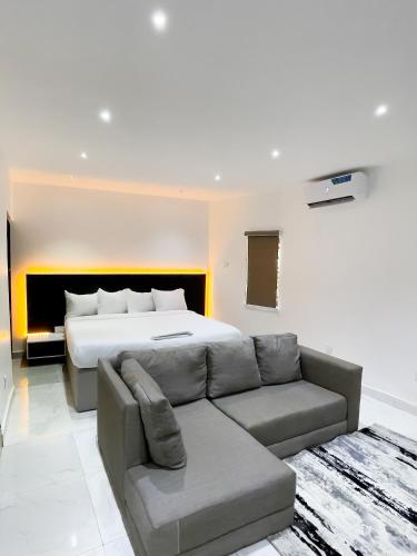 a living room with a bed and a couch at Luxe Apartments Surulere in Lagos