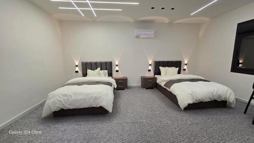 a bedroom with two beds and a flat screen tv at Jeeso hotel in Jerash