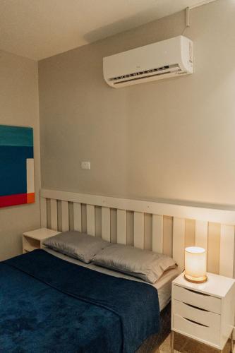 a bedroom with a bed and a air conditioner on the wall at Apartamento familiar com acesso privativo à Praia Mansa in Matinhos