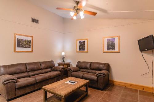 un soggiorno con 2 divani in pelle e una TV di Frio Country #17 a Concan