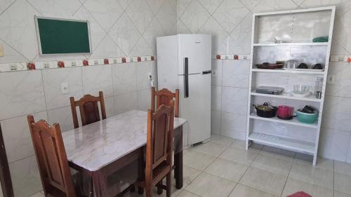 a kitchen with a table and a refrigerator at Excelente casa na Nova Maraba in Marabá