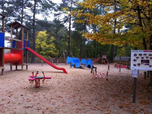 a playground with a red slide and a swing set at Proche châteaux de la Loire zoo Beauval gite de sologne 3 étoiles in Pruniers
