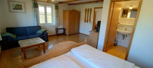 a living room with a bed and a blue couch at Oberamer Hof in Bad Saulgau