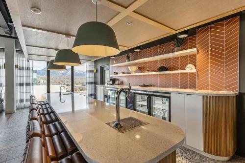 a kitchen with a large counter and some chairs at DT Studio Gym Pool Table 8th Floor Parking in Salt Lake City