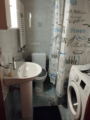 a bathroom with a sink and a toilet and a shower curtain at Gianis Homme in Alexandroupoli