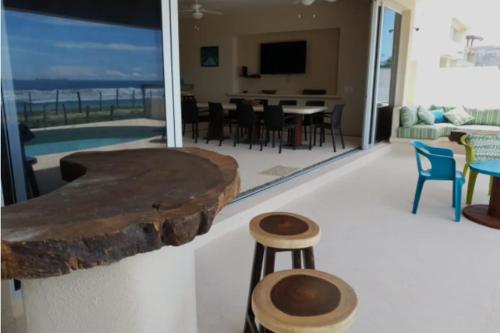 a living room with a couch and a table and chairs at New Beachfront Villa in Playa Blanca in Zihuatanejo