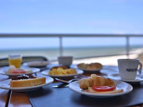 萨尔瓦多萨尔瓦多里奥福米罗美居酒店的餐桌上摆放着食物盘的桌子,海滩上摆放着