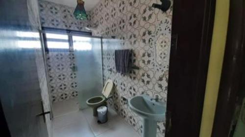 a bathroom with a shower and a toilet and a sink at Cantinho Charmoso no Guarujá in Guarujá