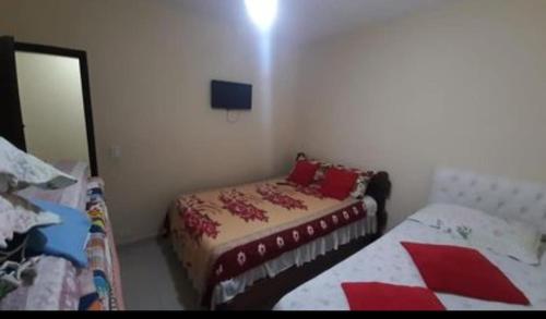 a small bedroom with a bed and a mirror at Cantinho Charmoso no Guarujá in Guarujá