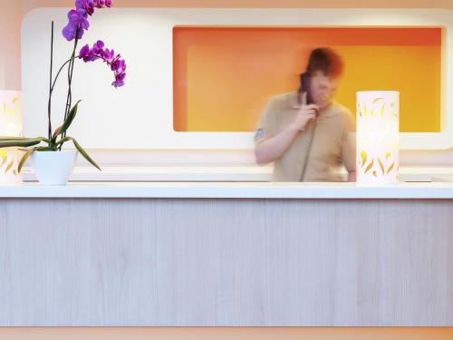 a person talking on a cell phone on a shelf at ibis budget Hotel Brussels Airport in Diegem