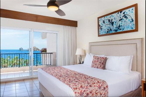 a bedroom with a bed and a view of the ocean at Villa Del Palmar in Cabo San Lucas