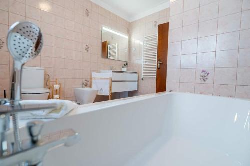 a bathroom with a tub and a sink and a mirror at Refúgio Do Artista Country House Viana Do Castelo in Mazarefes