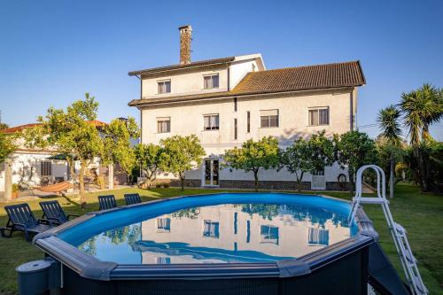 a swimming pool in front of a house at Refúgio Do Artista Country House Viana Do Castelo in Mazarefes