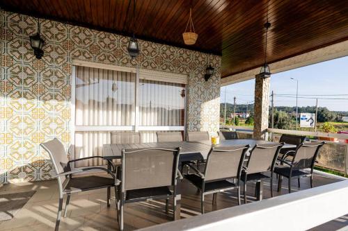 a dining room with a table and chairs on a patio at Refúgio Do Artista Country House Viana Do Castelo in Mazarefes