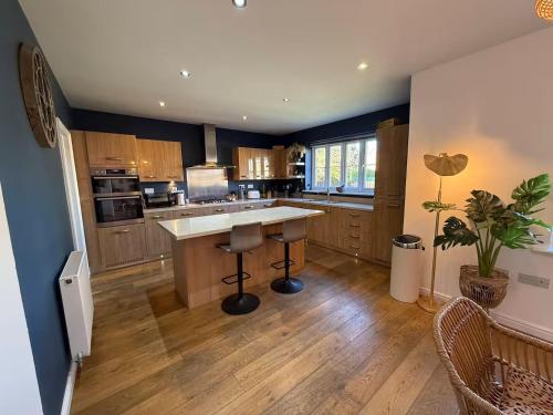 a large kitchen with a large island in the middle at West Lodge - Buxton in Buxton