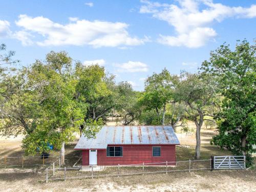 eine rote Scheune auf einem Feld mit Bäumen in der Unterkunft Relaxing River Getaway for 5 Unwind and Unplug in Schumannsville