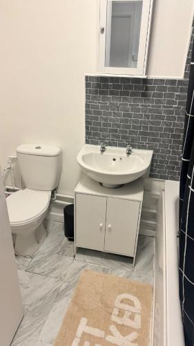 a bathroom with a white toilet and a sink at Modern 1-Bed Flat in Crystal Palace Sydenham in Sydenham