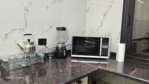 eine Küchenarbeitsplatte mit Mikrowelle und Mixer in der Unterkunft Jeeso Hotel in Gerasa