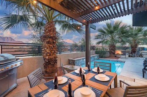 a patio with tables and a grill and a pool at 31| Pool Palace in St George with Snow Canyon View in Santa Clara