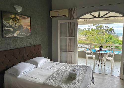um quarto com uma cama e uma varanda com uma mesa em Hotel & Pousada Bella Vista em Florianópolis